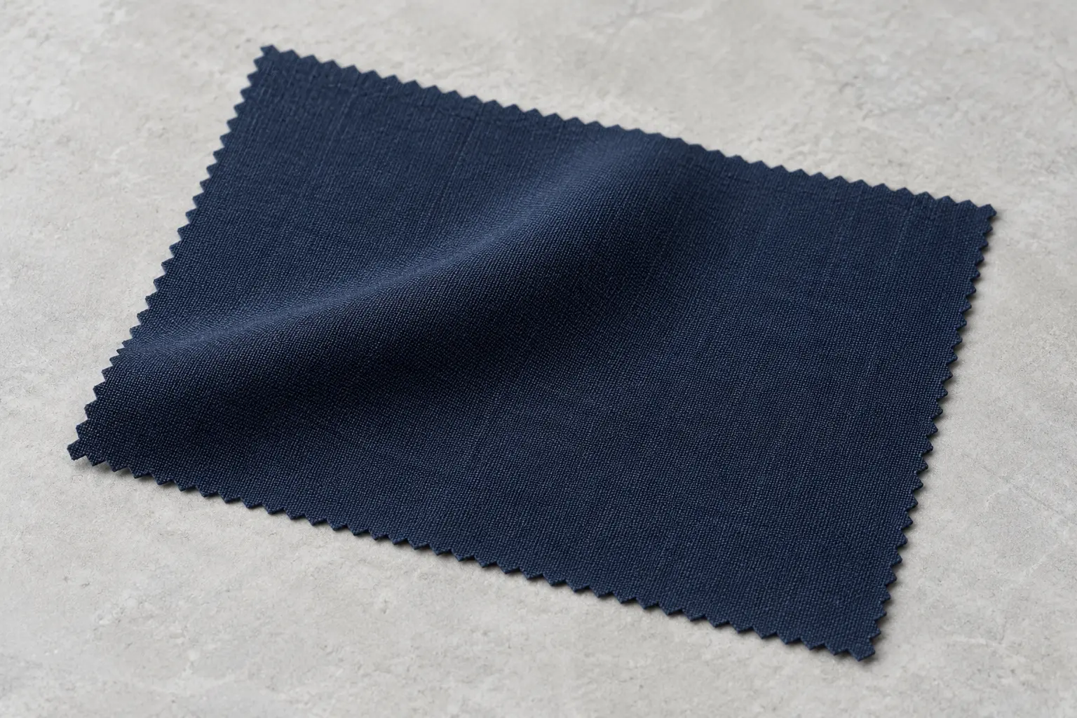 Mẫu suiting navy trải nếp nhẹ trên bàn màu sáng